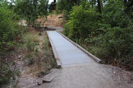 The compacted gravel trail transitions to boardwalk with edge protection